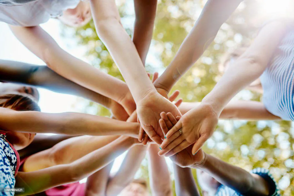 Personas uniendo sus manos en señal de apoyo