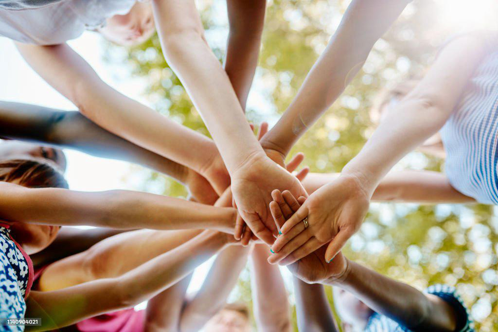 Personas uniendo sus manos en señal de apoyo